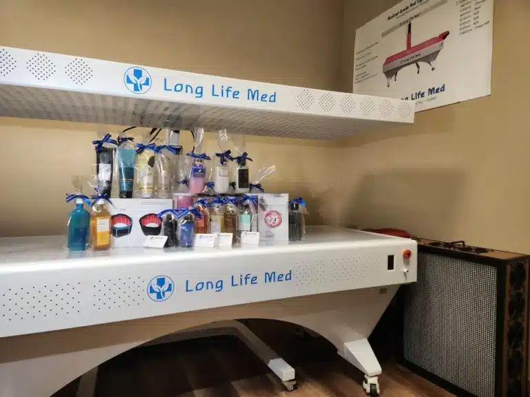 A display shelf labeled "Long Life Med" holds various gift bags and products, with a poster and air purifier visible in the corner, creating a welcoming atmosphere reminiscent of an Urgent Care in Las Vegas.